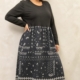 Robe midi grande taille noire à imprimé cachemire, buste uni et jupe froncée, portée par une femme ronde