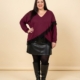 Pull effet croisé dentelle grande taille coloris bordeaux, porté avec une jupe simili cuir et des bottes