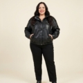 Veste en simili cuir noir à col montant fermé, mains dans les poches, grande taille