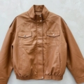 Veste en simili cuir camel à col montant, poches poitrine à rabat et bas élastiqué