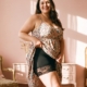 Femme ronde souriante soulevant sa robe fleurie et révélant un shorty anti-frottement noir à bande de dentelle – Fashion Curvy Shop