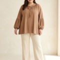 Tunique grande taille taupe à manches bouffantes portée par un mannequin ronde