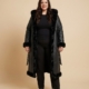 Manteau long grande taille en simili cuir noir doublé fausse fourrure, porté par une femme taille 52