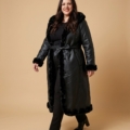 Manteau long grande taille en simili cuir noir doublé fausse fourrure, porté par une femme taille 52