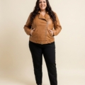 Perfecto en simili cuir camel grande taille porté fermé, mains dans les poches zippées